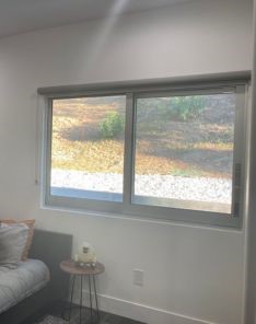 Yorba Linda boy’s bedroom before window treatment, displaying bare windows and natural sunlight prior to roller shade installation.