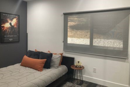 Modern Yorba Linda bedroom with roller shades fully lowered, showing privacy and style with pull down window shades.