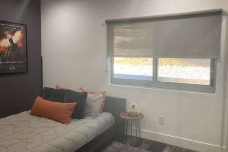 Bright boy’s bedroom in Yorba Linda featuring half-pulled down sheer roller shades for windows, allowing soft daylight.